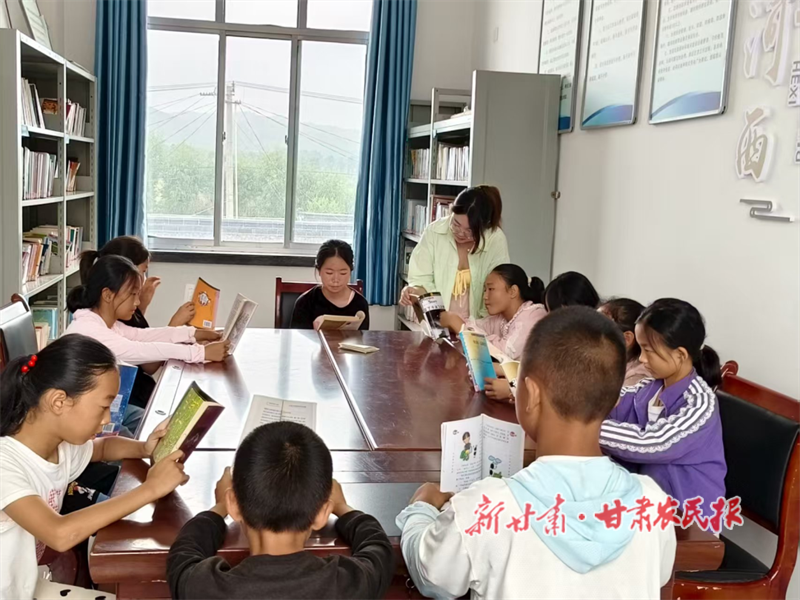 河西鎮(zhèn)“青年之家”里孩子們圍坐在一起看書.png